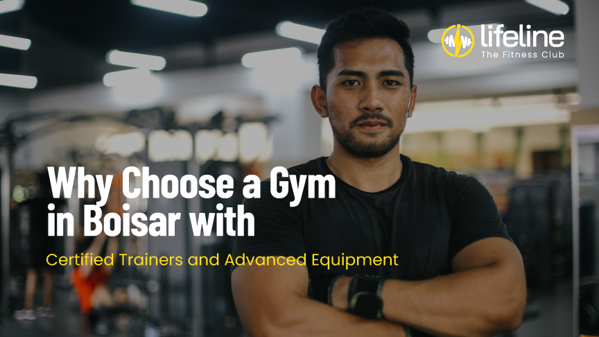 A confident male fitness trainer standing with arms crossed in a modern gym